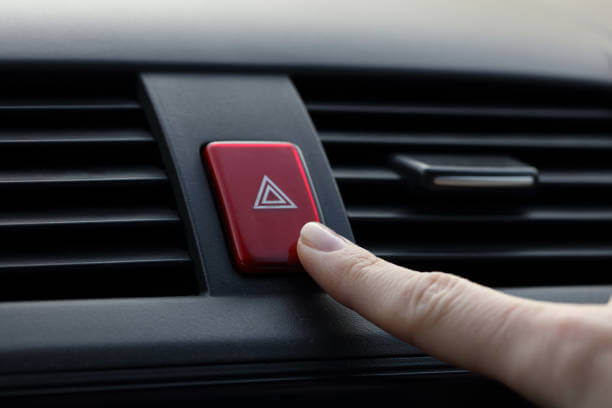an image of a person's finger turning on their hazard lights