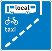 A image of a With-flow bus lane ahead which pedal cycles and taxis may also use road sign